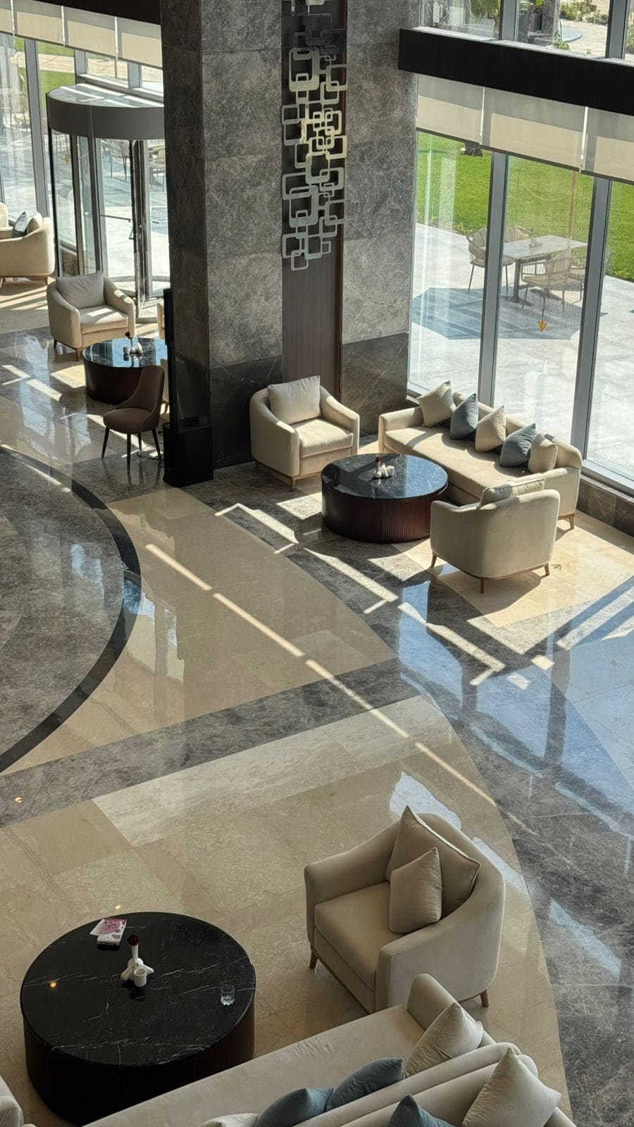 Lobby seating at Rixos Montaza seen from above, sunlight across the marble