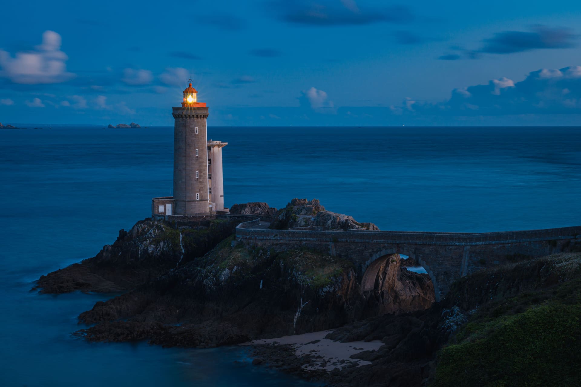A lighthouse on the Mediterranean shore at dusk